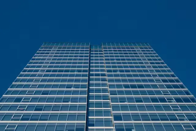 Low-angle view of a modern glass skyscraper against a clear blue sky in Montreal, Canada.